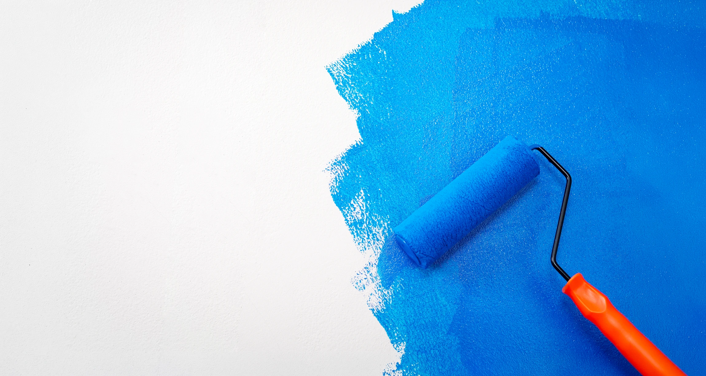 Peintre professionnel appliquant de la peinture blanche au rouleau sur un mur intérieur